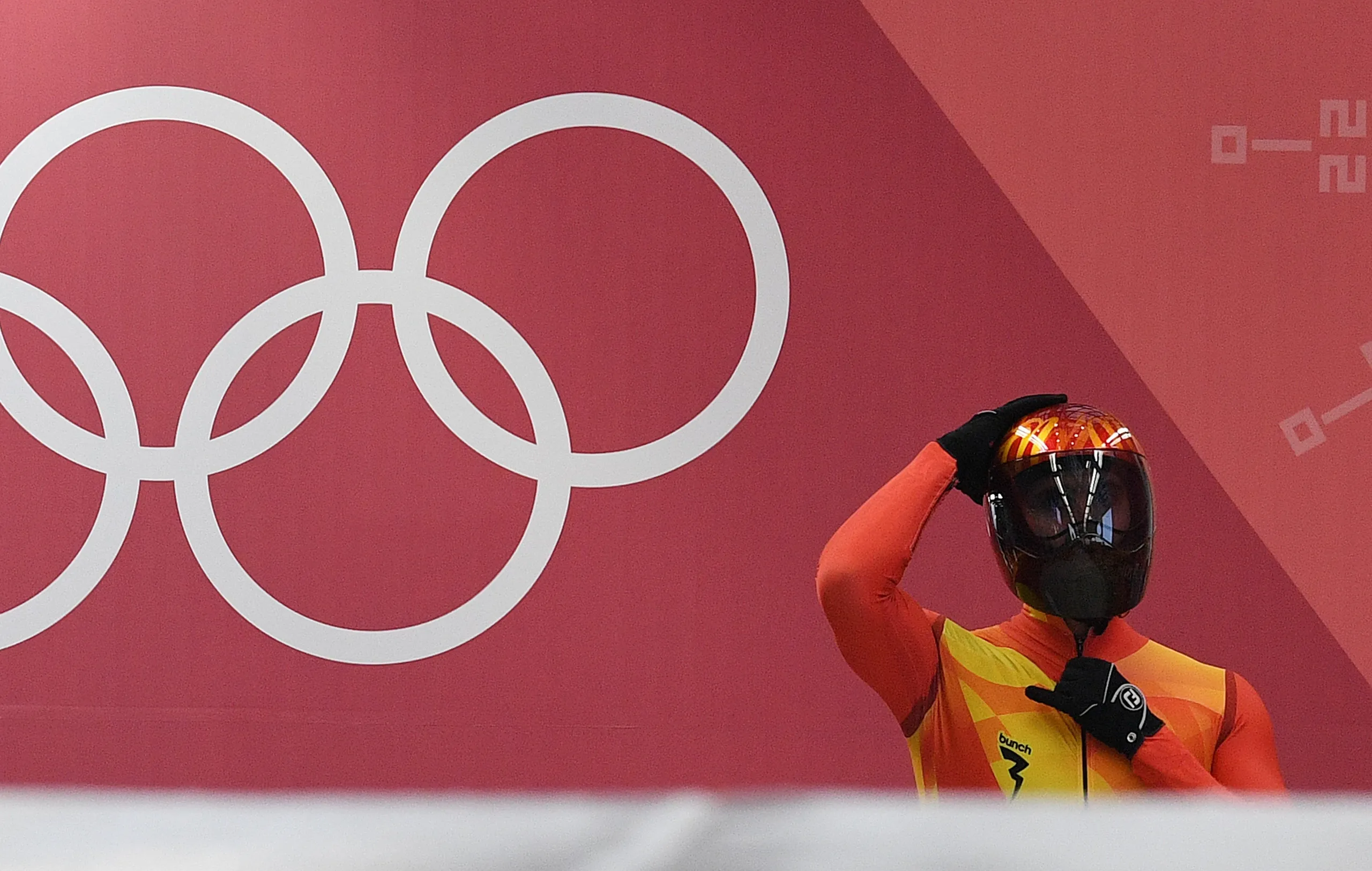 Ander Mirambell con la equipación completa de skeleton ante los aros olímpicos
