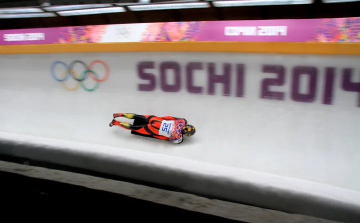 Ander Mirambell desciende por la pista ante el muro con el rótulo Sochi 2014 y los aros olímpicos